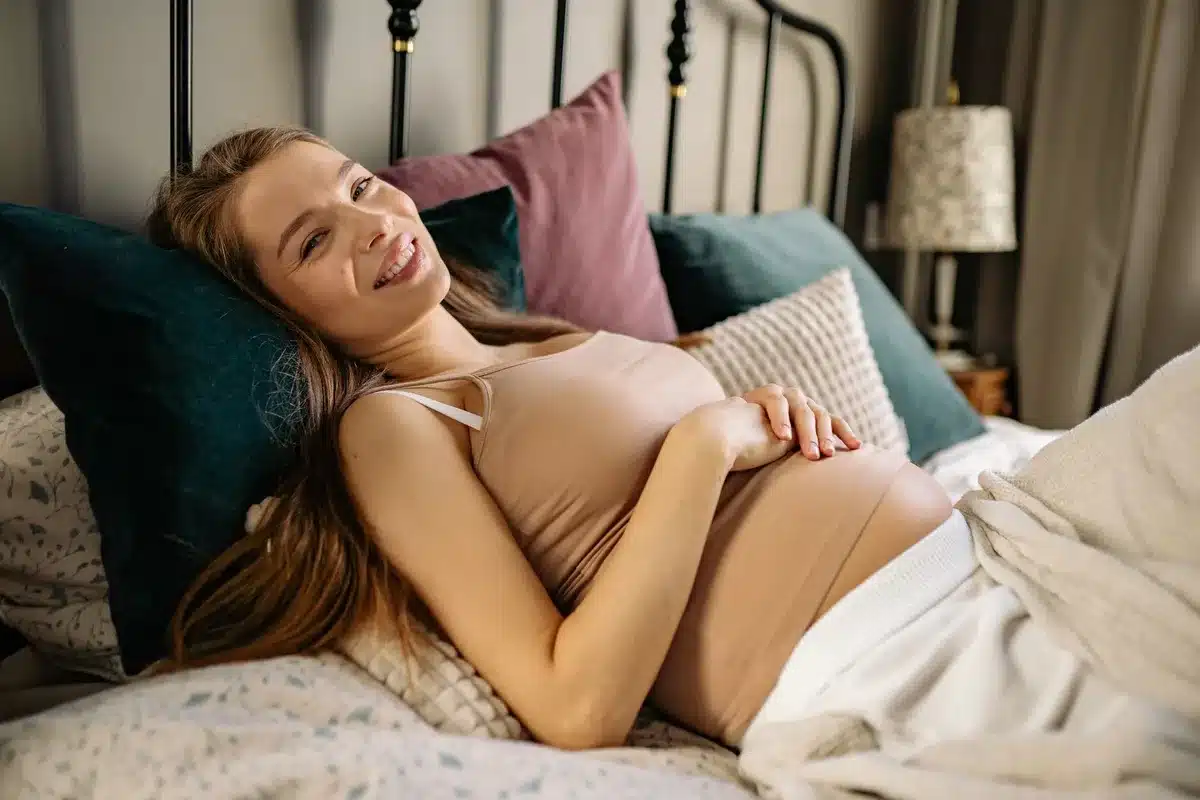 Femme enceinte dormant en position semi-allong&eacute;e avec la t&ecirc;te sur&eacute;lev&eacute;e
