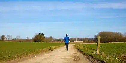 Coureur en mouvement sur un sentier, posture dynamique et alignée.