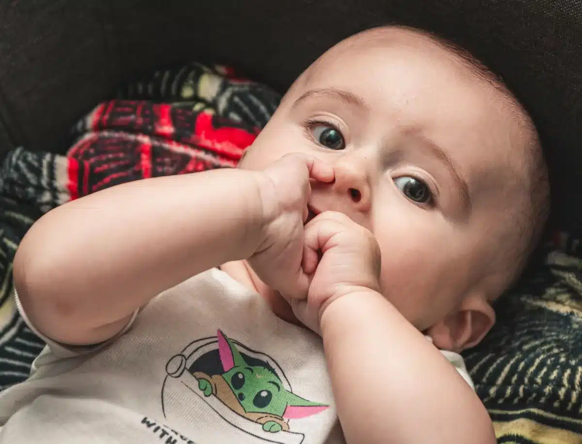 B&eacute;b&eacute; avec joues rouges et gencives gonfl&eacute;es montrant les signes de pouss&eacute;es dentaires