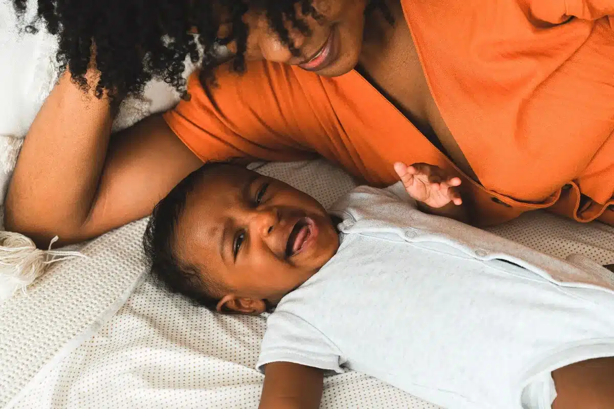 Parent massant délicatement la gencive enflée d'un bébé pour soulager la douleur des poussées dentaires