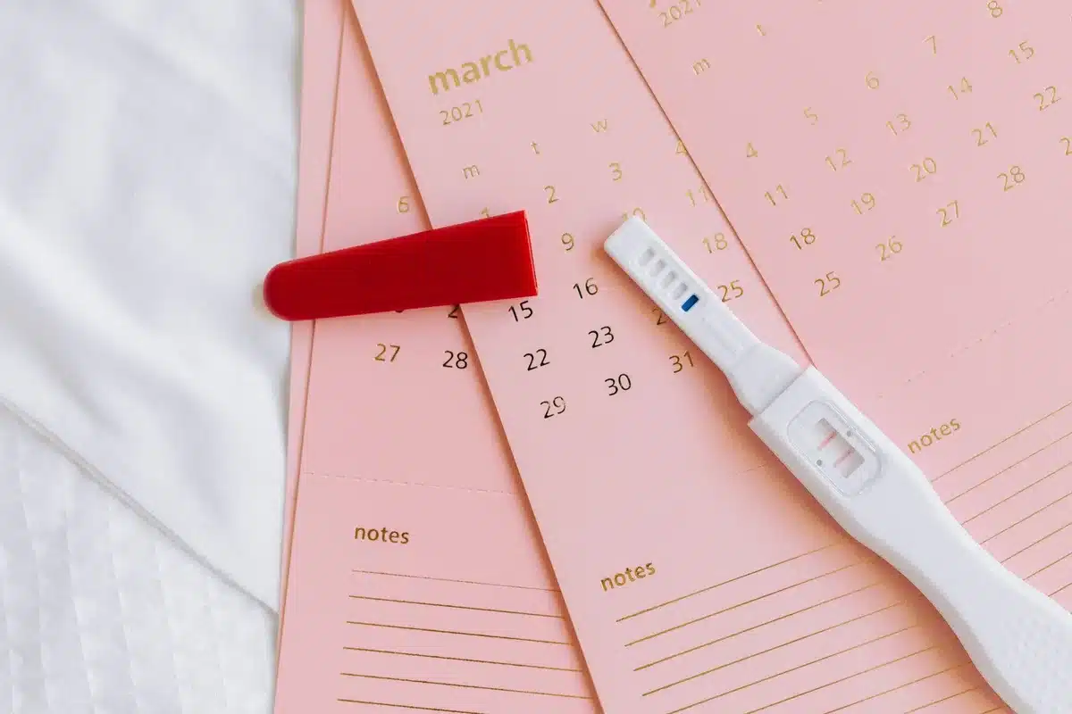 Femme notant les signes d'ovulation sur un calendrier de suivi du cycle
