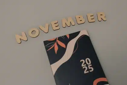 Main tenant un thermomètre basal près d'un calendrier de suivi du cycle menstruel à la lumière du matin