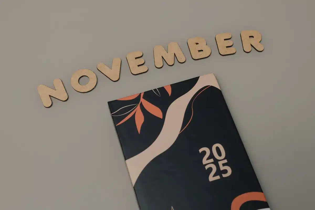 Main tenant un thermomètre basal près d'un calendrier de suivi du cycle menstruel à la lumière du matin