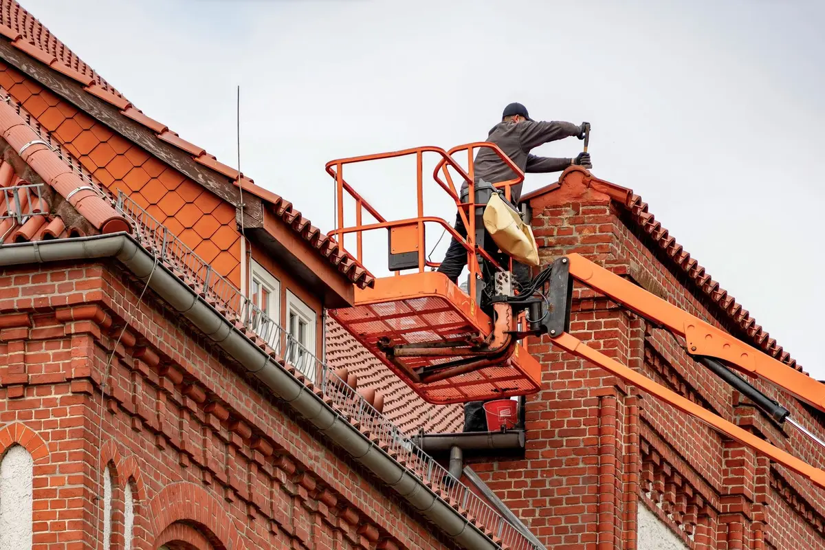 Inspection d'une toiture endommagée montrant des planches abîmées à remplacer