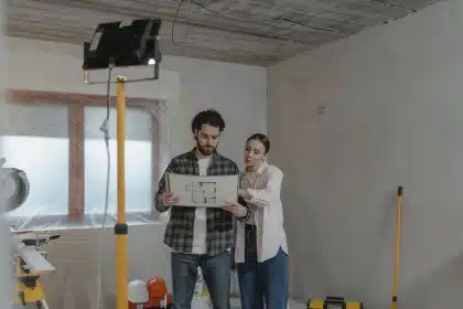 Plans de construction et mètre posés contre un mur d'intérieur d'habitation