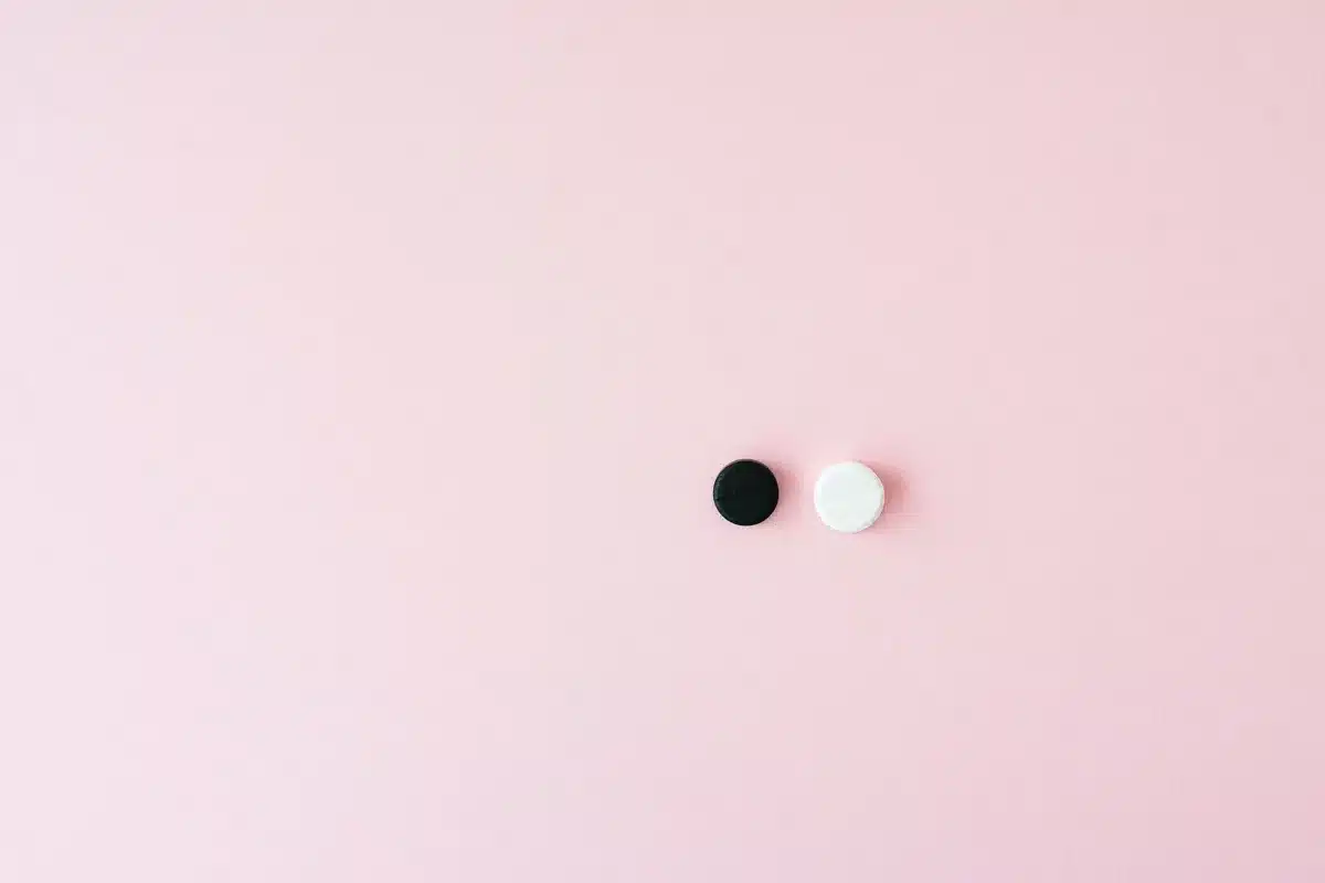 Plaquette de comprimés hormonaux et calendrier sur une table de nuit