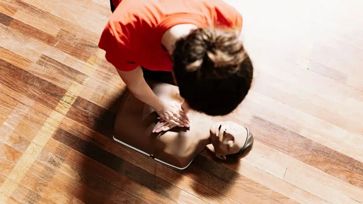 Mains effectuant des compressions thoraciques sur un mannequin lors d'une formation aux premiers secours