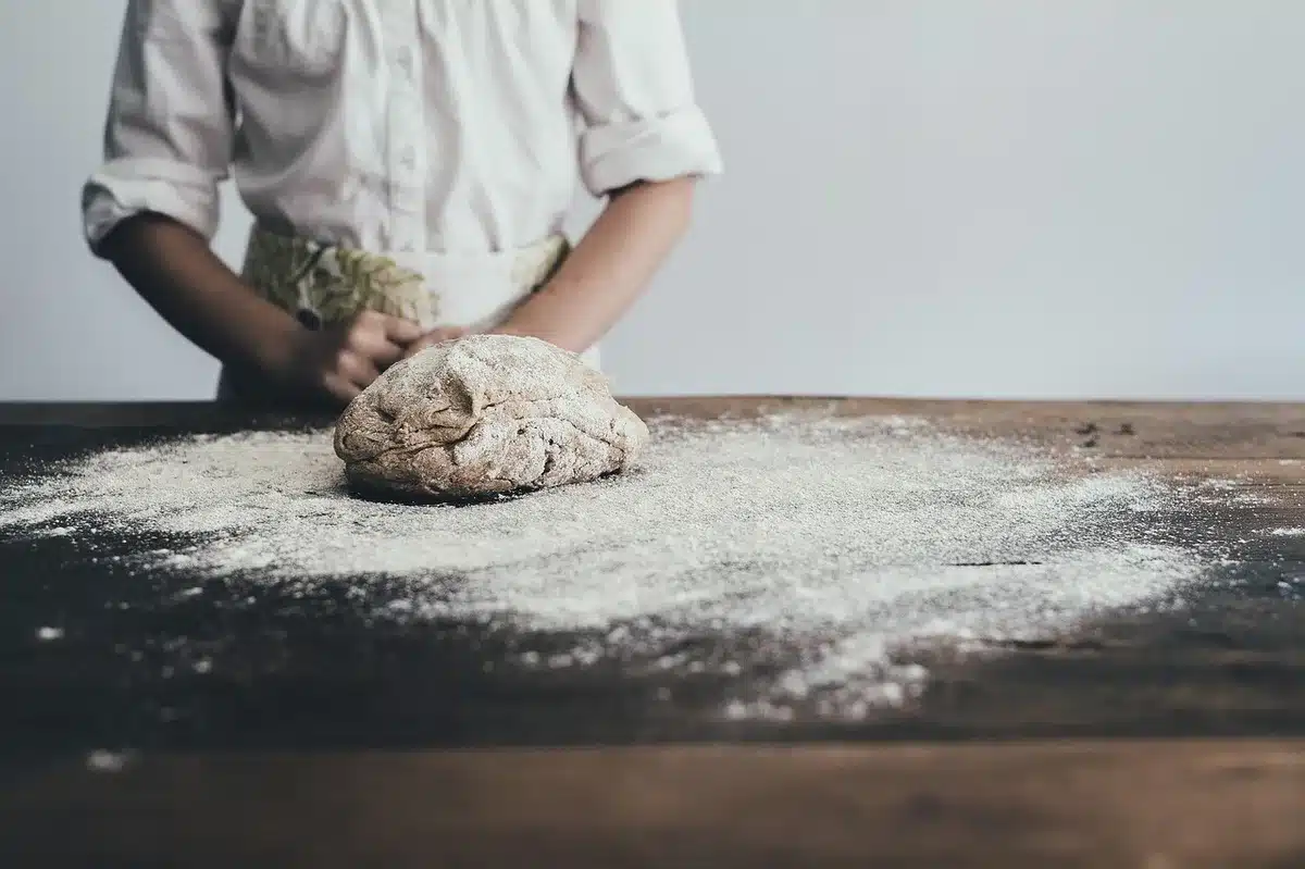 Livre de recettes ouvert avec des pommes fraîches et des ustensiles de cuisine sur une table en bois