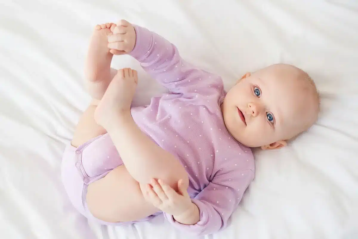Bébé qui commence à se retourner et à se redresser dans son berceau