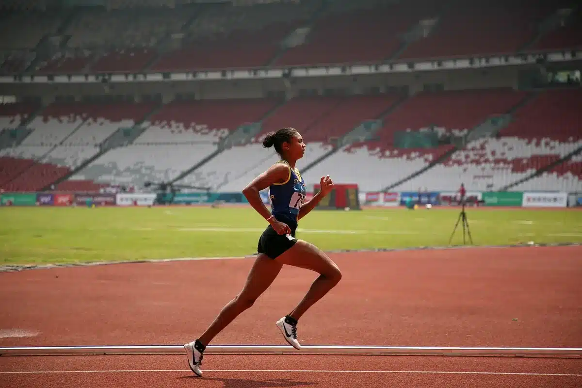 Un coureur consulte sa montre de sport pour suivre les calories br&ucirc;l&eacute;es pendant l'effort.