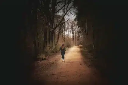 Un coureur en action sur un sentier, au lever du soleil, montrant l'effort et la régularité nécessaires pour perdre du p
