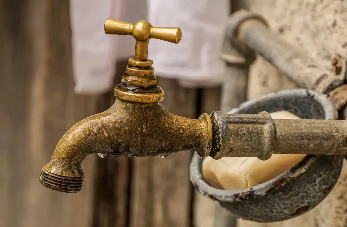 Étapes du lavage des mains montrées par des mains sous l'eau au-dessus d'un lavabo