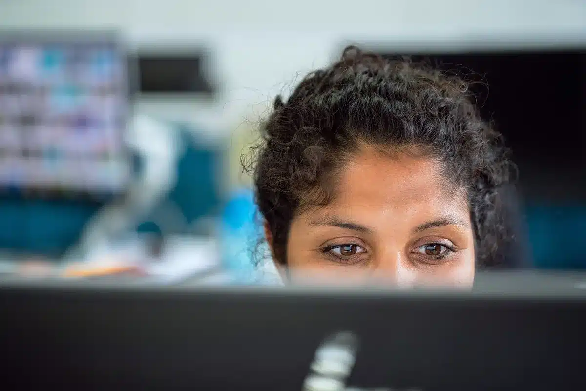Femme concentrée à son bureau, montrant les défis de concentration liés au TDAH