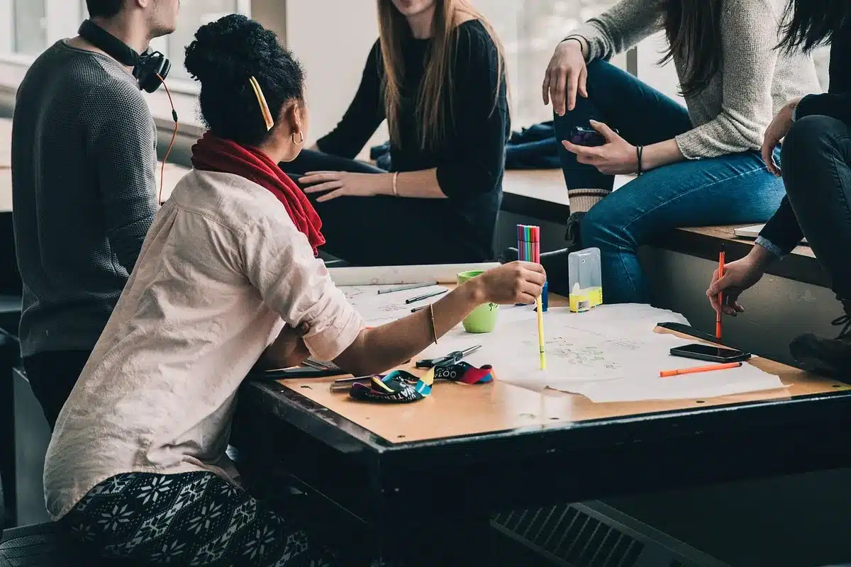Adolescent étudiant à la maison avec ordinateur et cahier en journée
