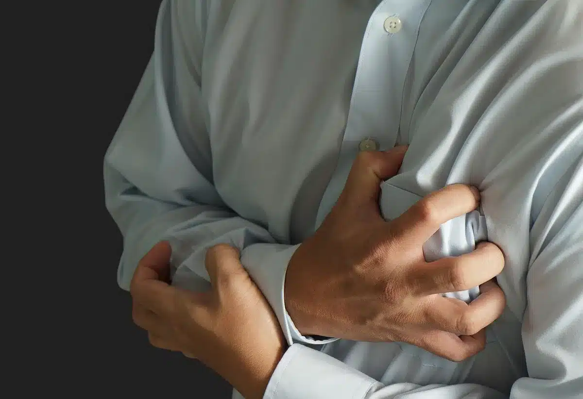 Personne assise, tête dans les mains, montrant la détresse émotionnelle et la tension corporelle liée à la somatisation