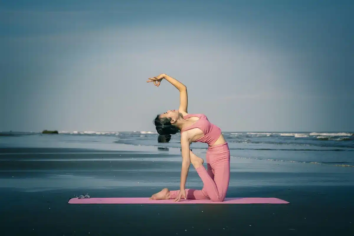 Personne faisant du yoga doux sur un tapis près d'une fenêtre en journée
