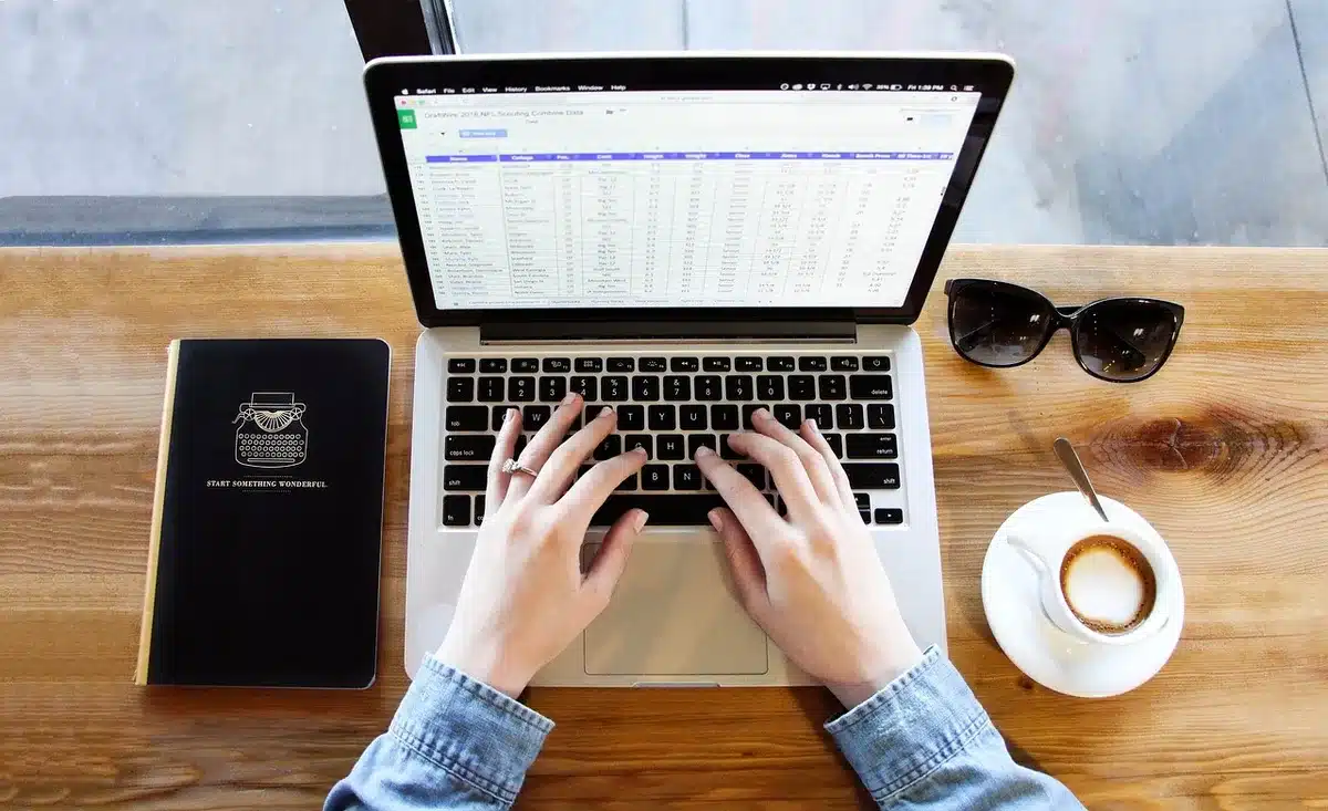 Main écrivant des objectifs et planning sur un carnet au bureau