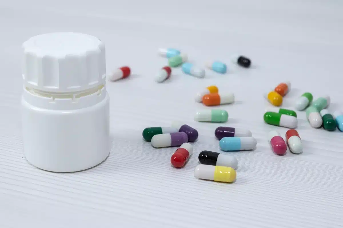 Gélules de biotine sur une table claire près d'une fenêtre