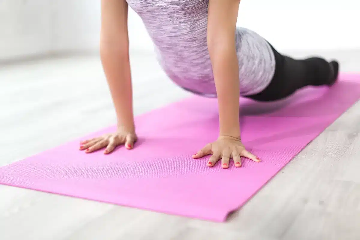 Personne utilisant un tapis de sol pour des exercices sans matériel
