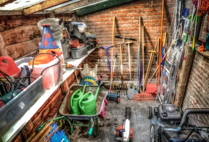 Atelier de jardinage en journée avec établi et outils suspendus près d'une fenêtre