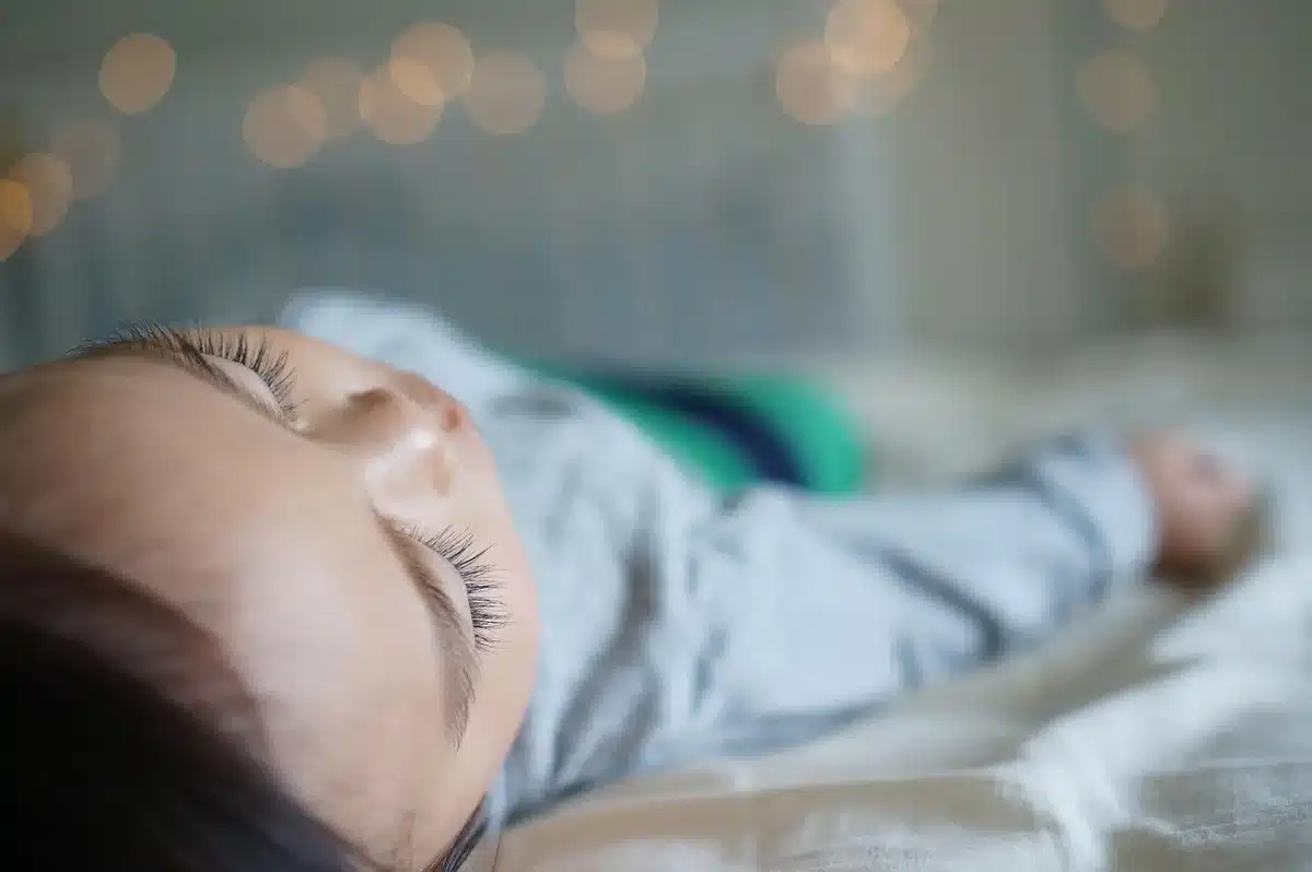 Bébé en position ventrale sur une couverture, sous surveillance