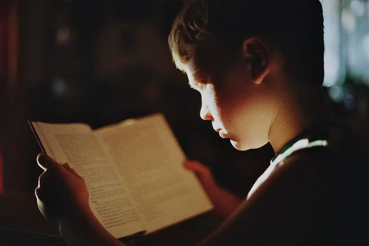 Enfant concentré lisant un livre, montrant curiosité et attention